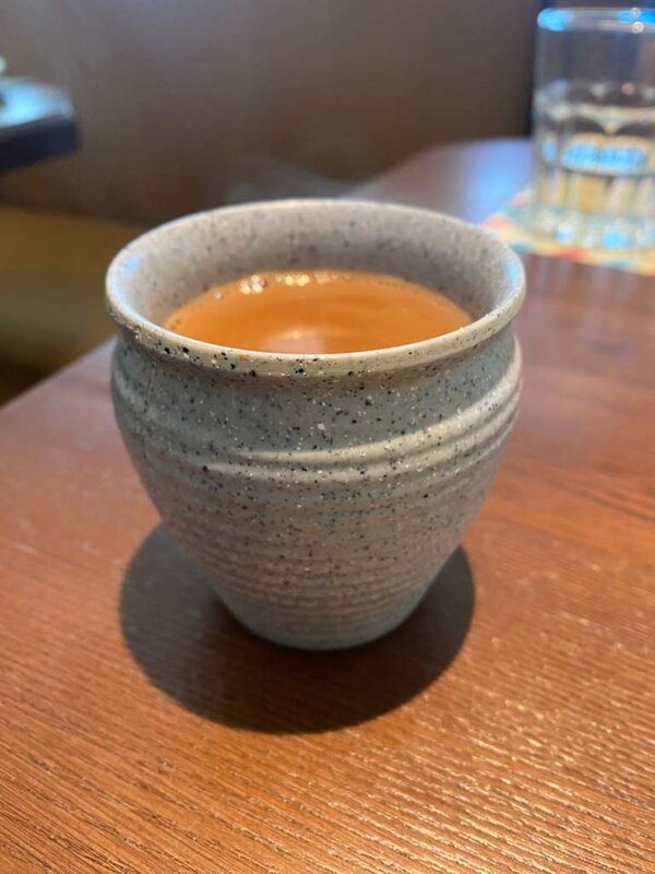Before: raw phone photo of chai in warm restaurant lighting